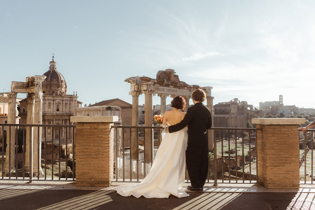 Couple embracing on a terrace overlooking Rome during a luxury elopement