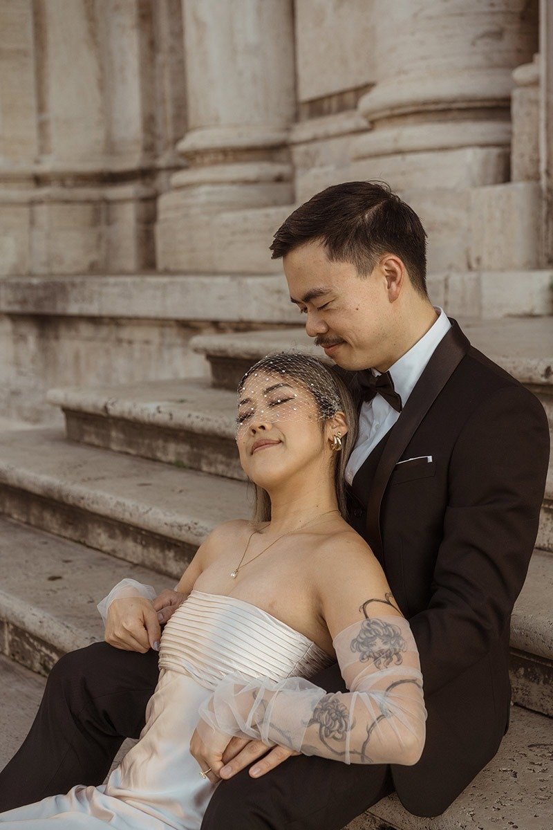 Romantic couple embracing near historic architecture during a Rome elopement