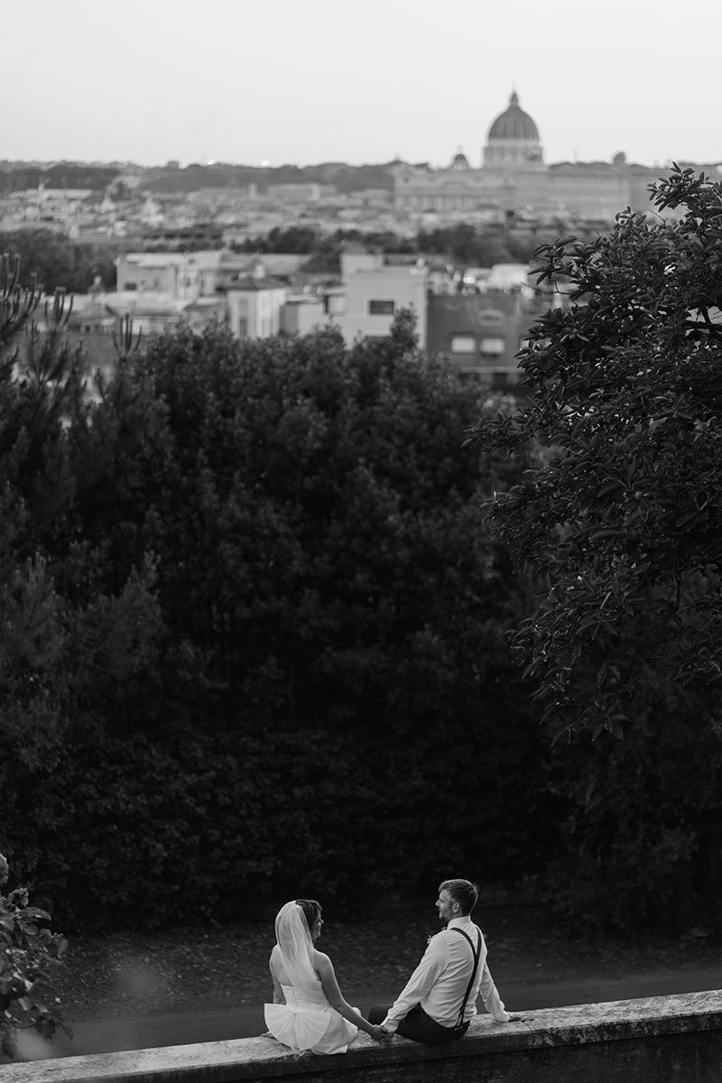 Couple sitting on a terrace overlooking Rome during a romantic elopement