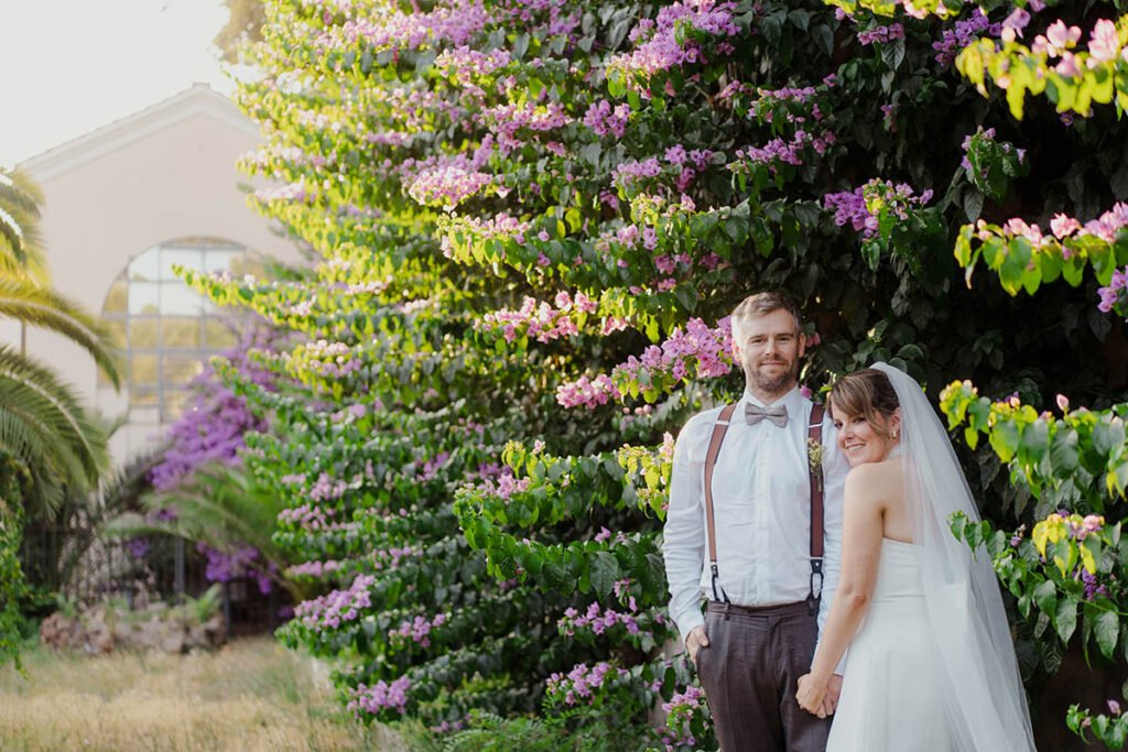 Elopement couple smiling under a blooming purple tree in Villa Borghese.