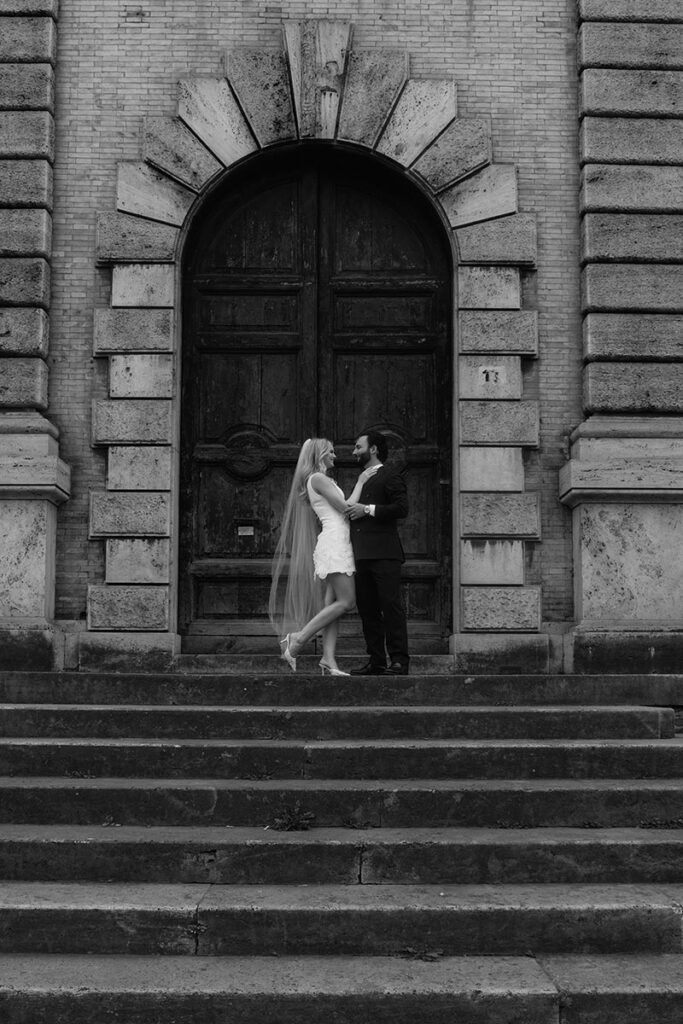 Bride and groom standing in front of an ancient Roman doorway – captured by an elopement photographer in Rome