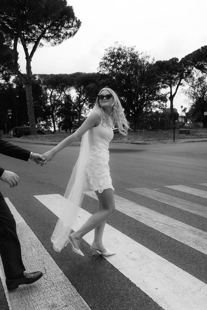 Bride crossing a Roman street with confidence – modern city elopement captured by a Rome wedding photographer
