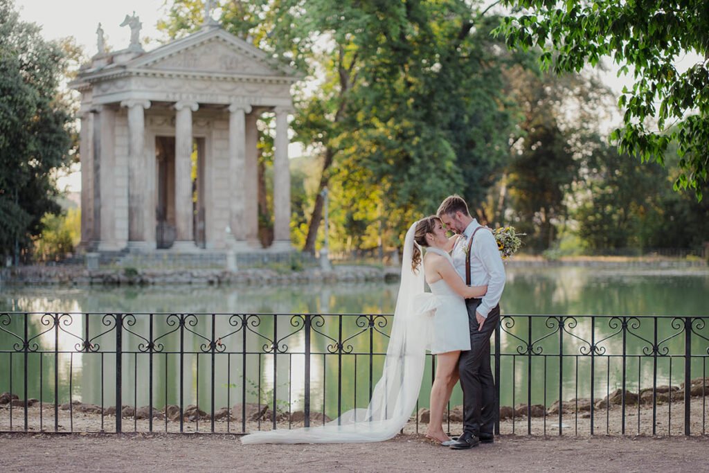 Bride and groom standing closer near Temple of Asclepius in Villa Borghese.