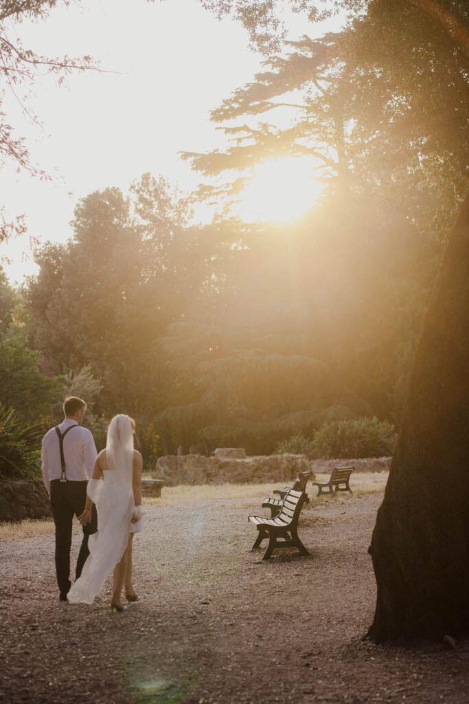 Elopement couple walking away toward the sunset in a Roman park.