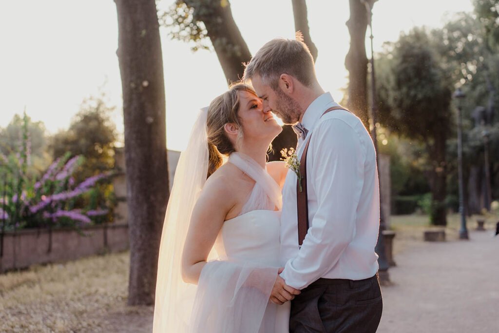 Bride and groom smiling at each other on a sunny terrace in Rome.
