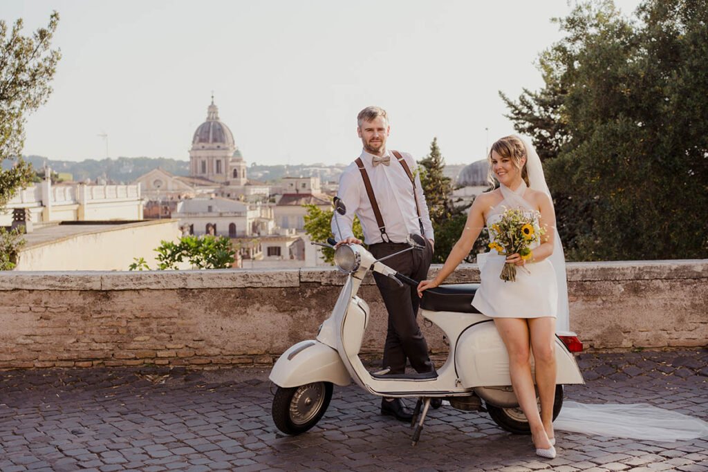Couple standing with a vintage Vespa and Rome’s skyline behind them.