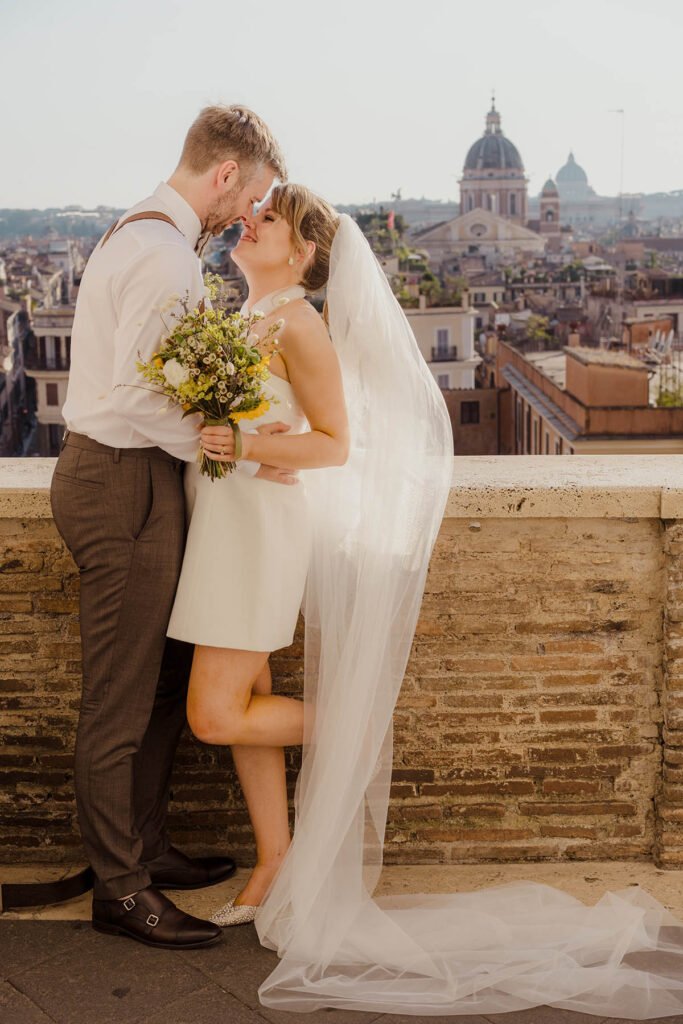 Bride holding bouquet with city view behind her during Rome elopement.