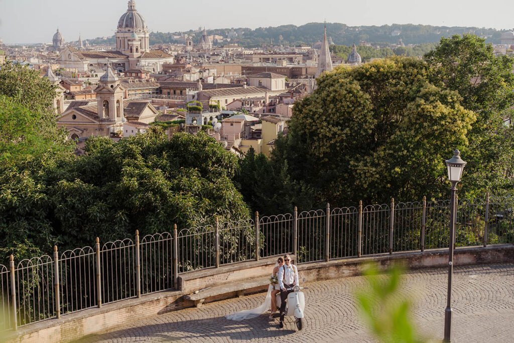 Couple arriving on a Vespa with the city of Rome in the background.