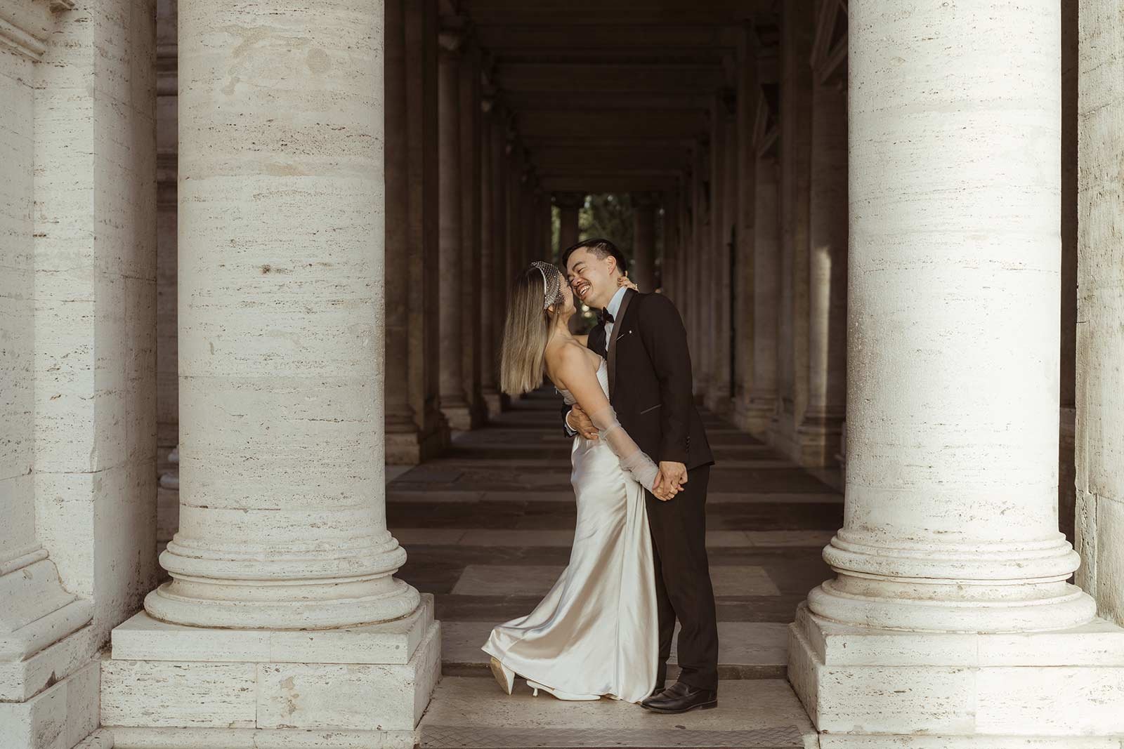 Bride and groom leaning on railing with Roman Forum view