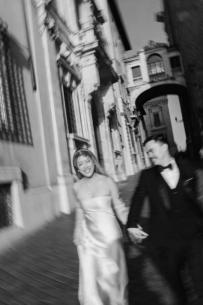 Rome elopement couple walking hand in hand through cobblestone street