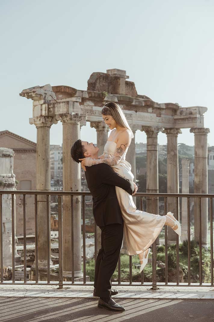 Groom lifting bride at Roman Forum ruins during Rome elopement