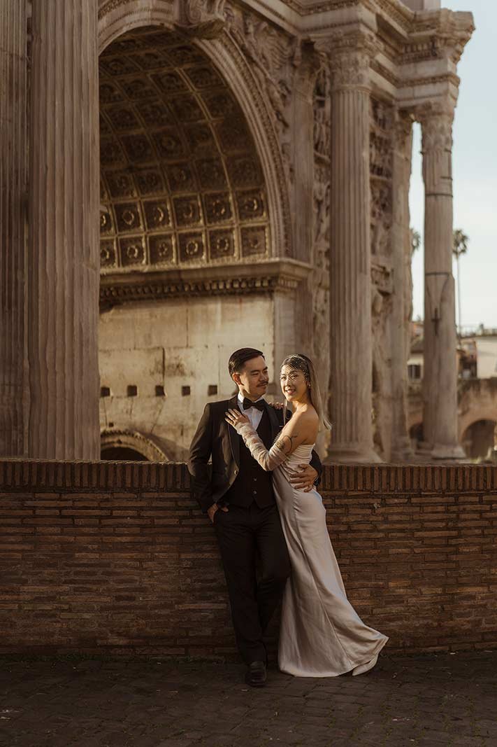 Rome elopement couple posing under ancient Roman archway