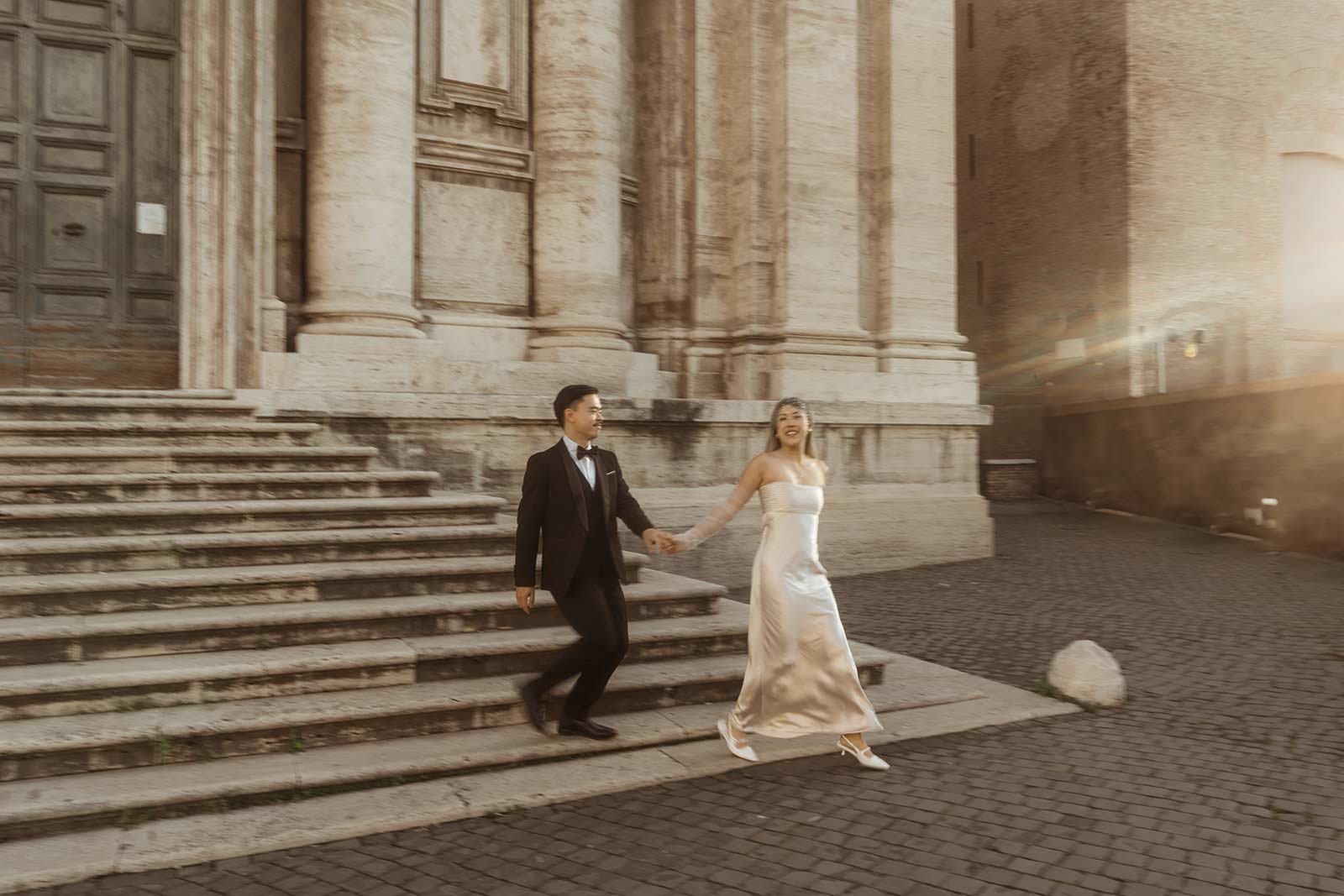 Bride and groom walking down church steps hand in hand during Rome elopement