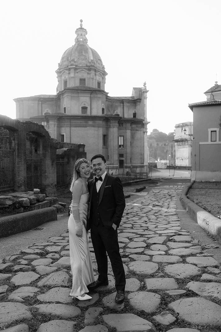 Black and white elopement photo of a couple on ancient Roman cobblestones