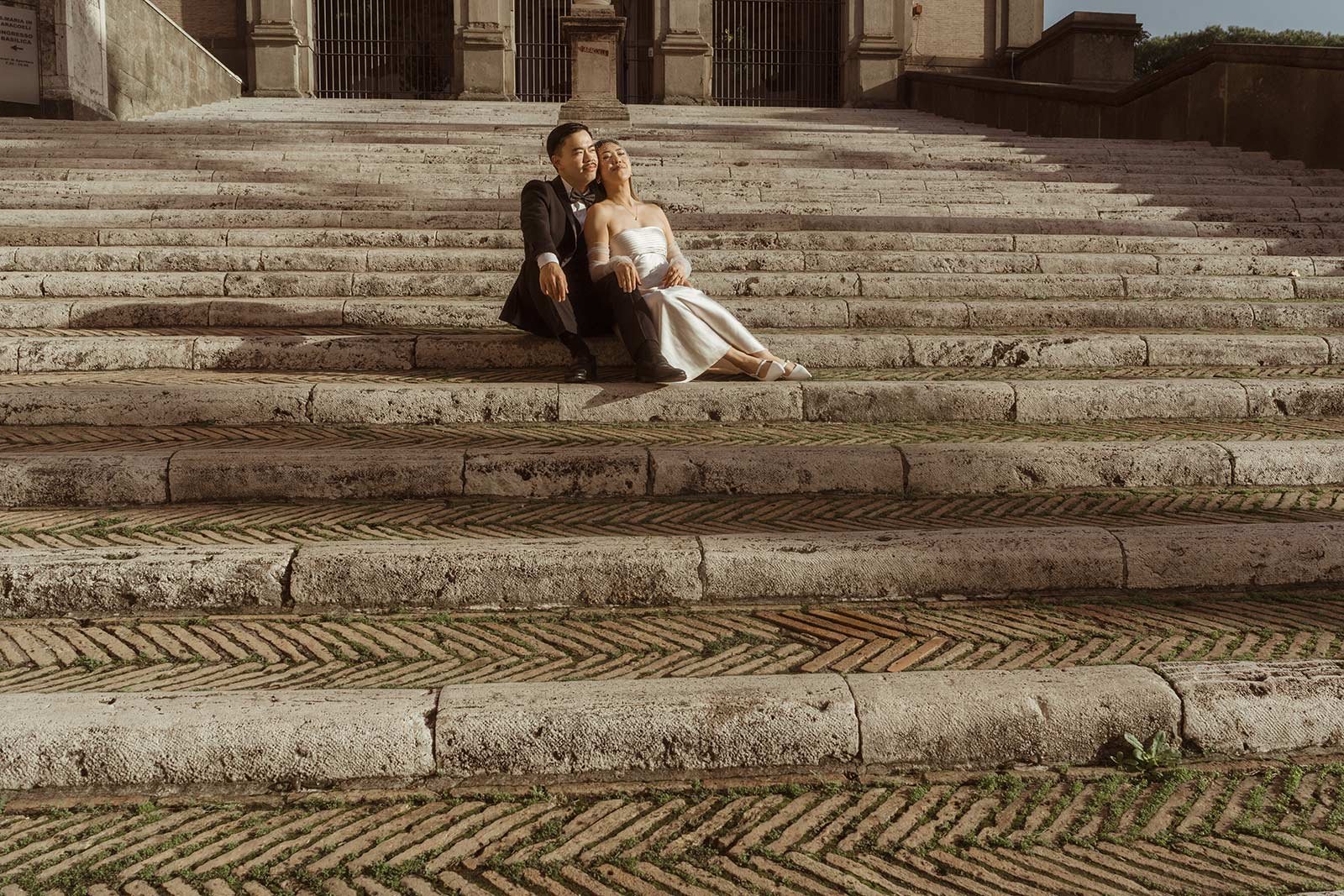 Bride and groom sitting together on the Capitoline Hill stairs during Rome elopement