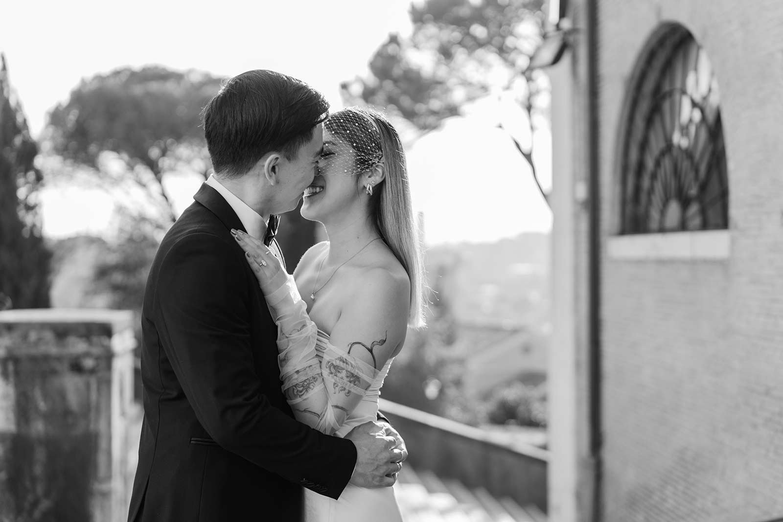 Rome elopement kiss with bride smiling under soft morning light