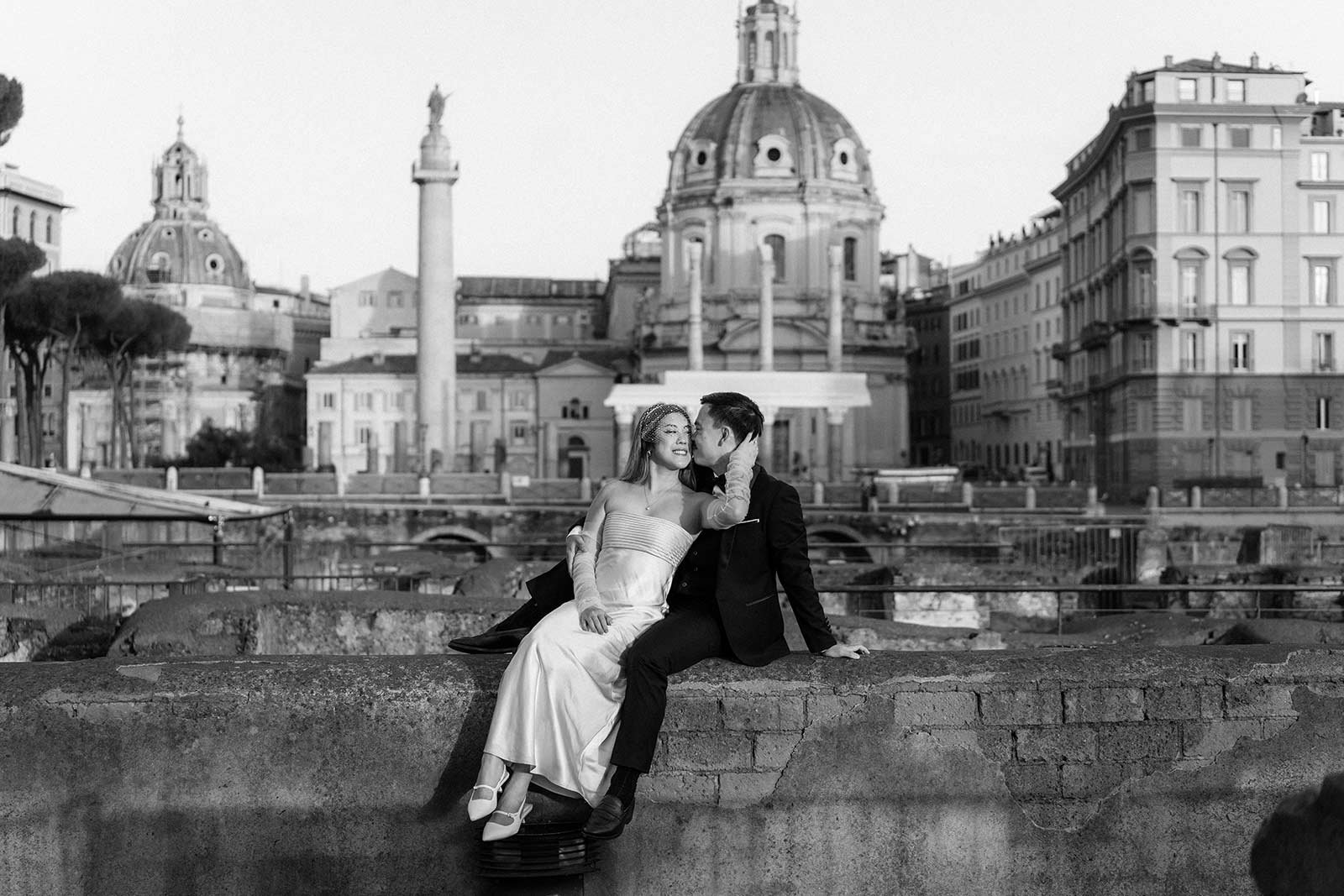 Black and white elopement photo of a couple by Trajan’s Column in Rome