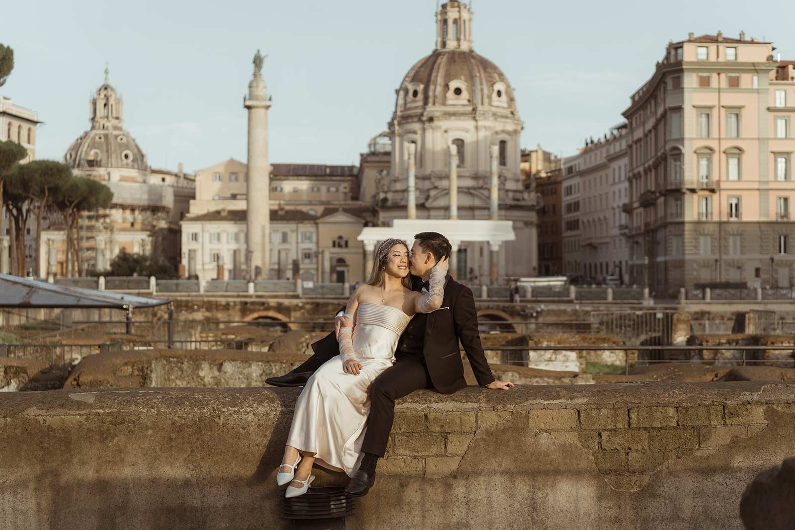 Couple kissing during their Rome elopement in front of Trajan’s Column