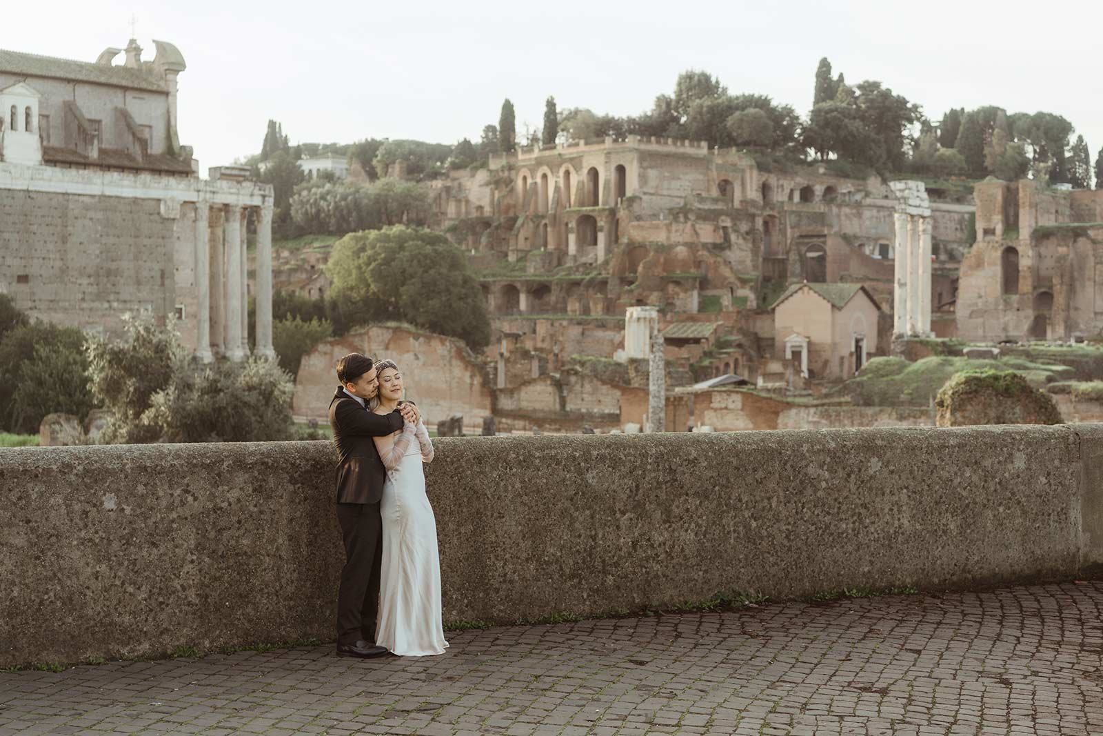 Couple embracing with the Roman Forum ruins in the background during Rome elopement