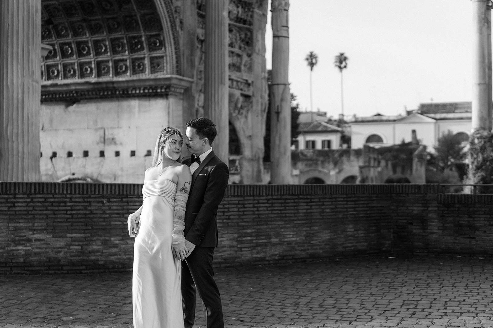 Bride and groom holding hands by the Roman Forum ruins during their elopement